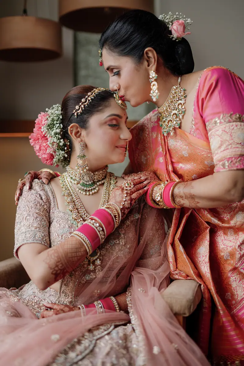 A mother kissing her daughter's forehead before the ceremony