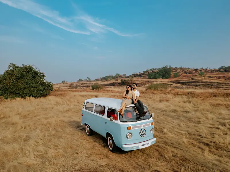 A drone frame of a couple on a camper van in open country