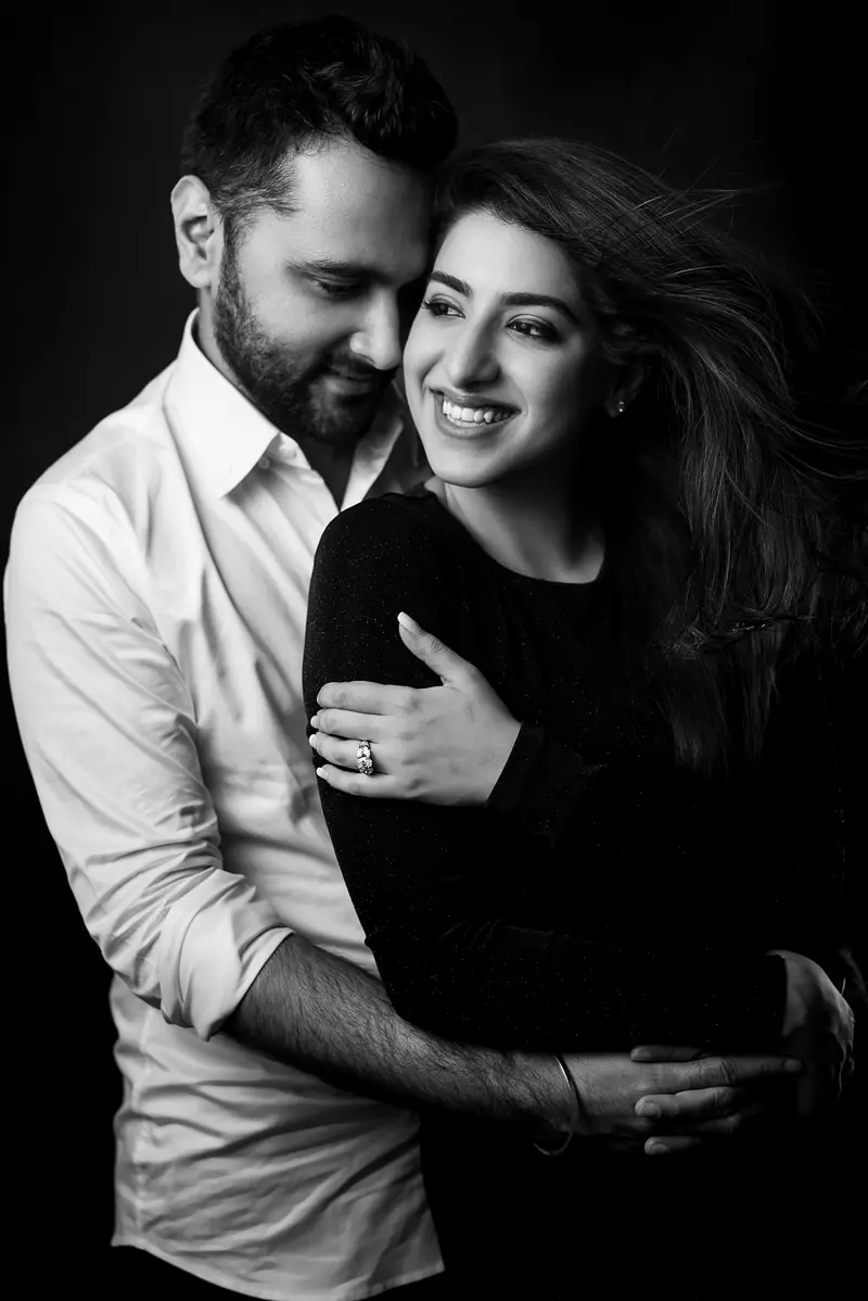 A black and white portrait of a couple holding each other