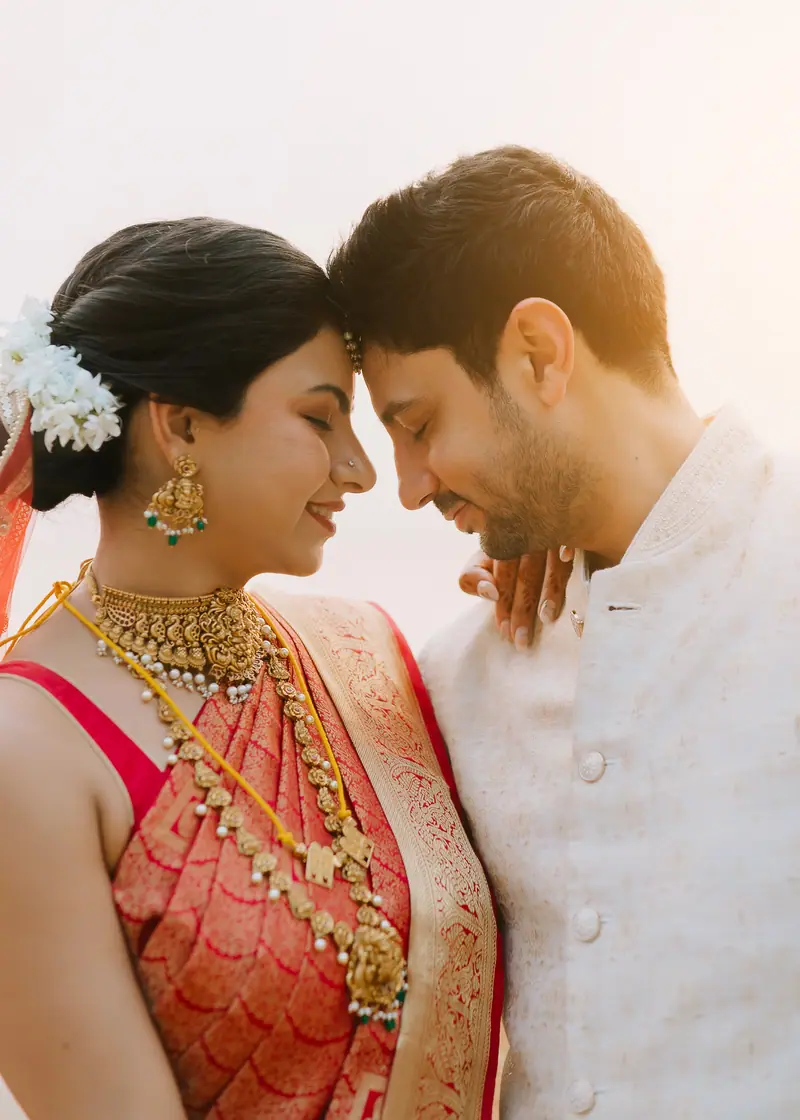 Bride and groom, foreheads touching, laughing