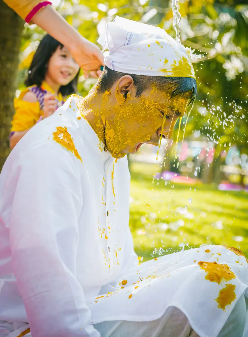 Haldi being pressed onto the groom's face in Kerala