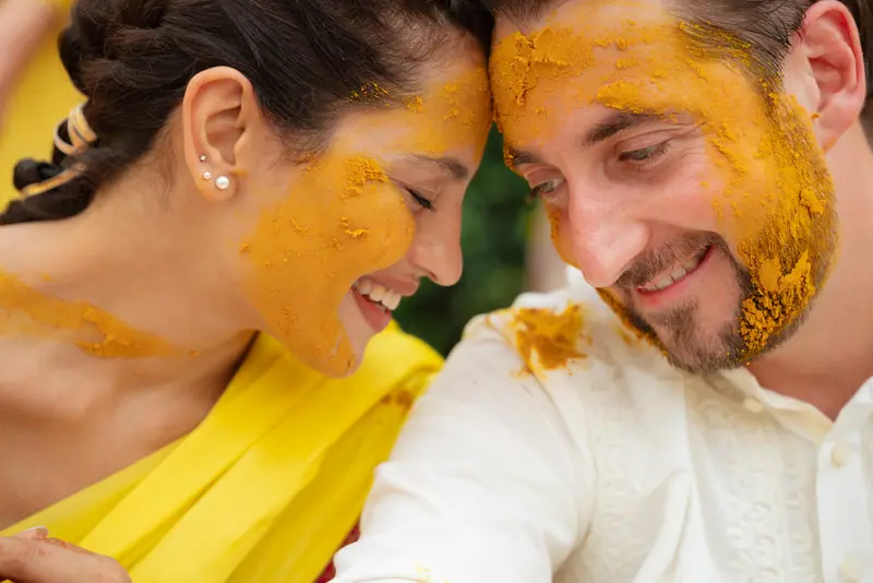 Turmeric-covered faces at a haldi ceremony