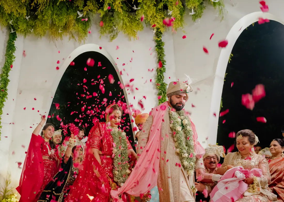 Bride and groom walking under a shower of petals on the wedding day