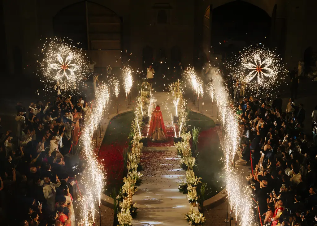 Bride and groom at the mandap under a canopy of fireworks